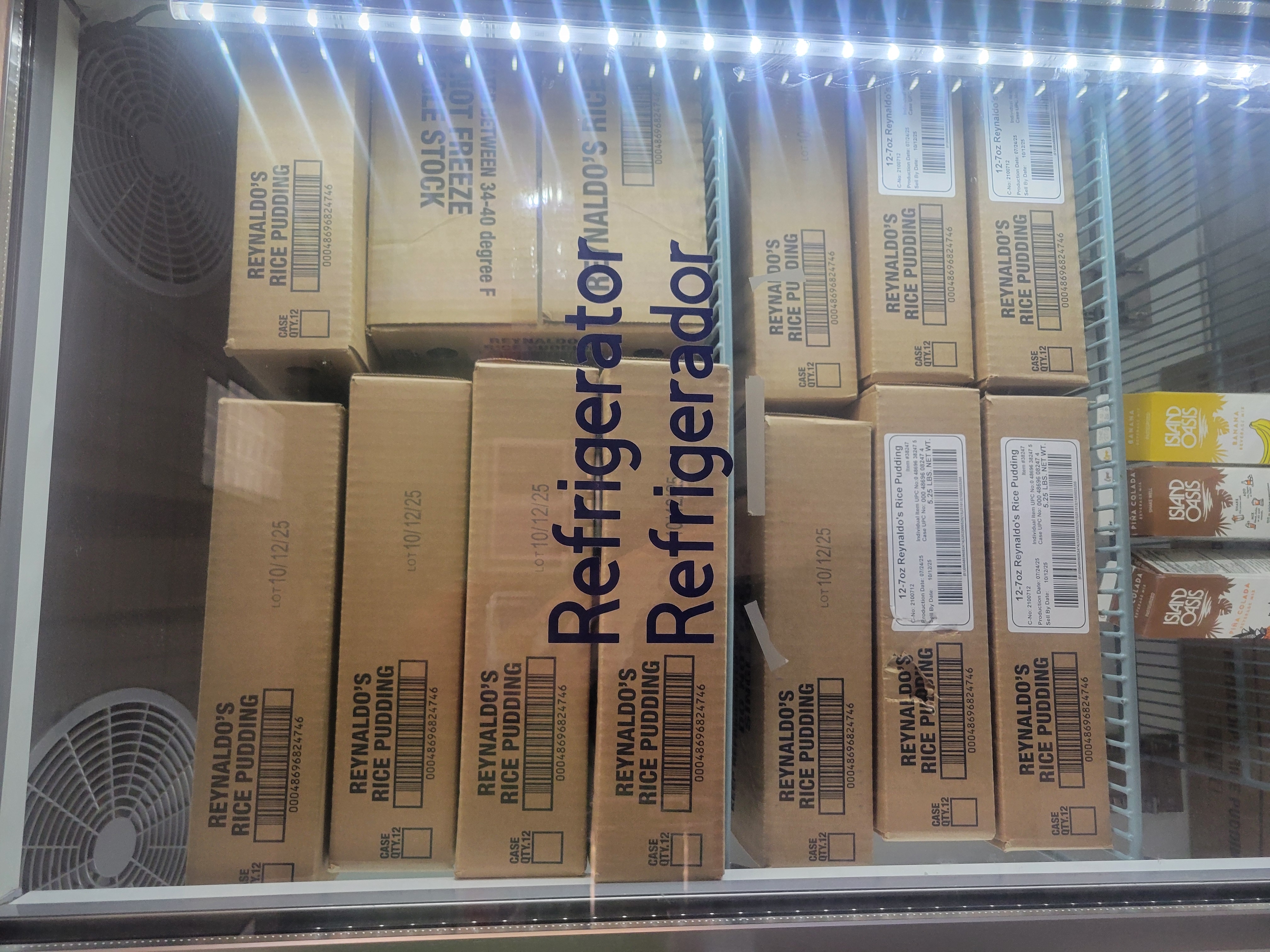 Two shelves filled with boxes of rice pudding and the last shelf was three drink mix in a fridge.